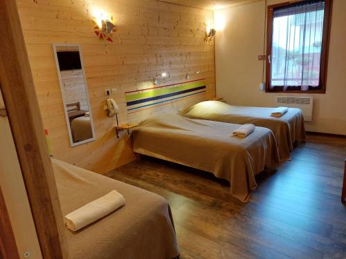 a room with two beds in a log cabin at Le Magiot in Montliot-et-Courcelles