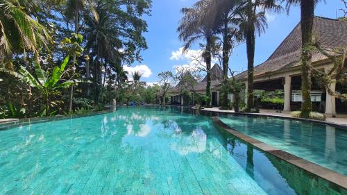 
a swimming pool with a pool table and chairs at Pandawa Ubud Hotel in Ubud
