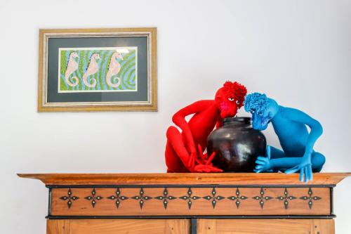 two statues of people sitting on top of a dresser at The Flame Tree Estate & Hotel in Kandy
