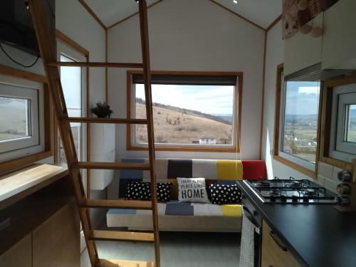 una habitación con una escalera en una casa pequeña en Tiny House Cluj with Jacuzzi, en Sînnicoară