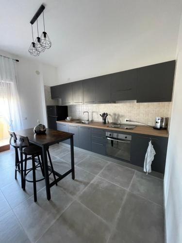 uma cozinha com uma mesa e uma mesa e cadeiras em Appartamento Calilla em Taranto