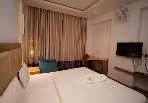 a hotel room with a bed and a flat screen tv at HOTEL AMORA - Rajnandgaon in Rāj Nāndgaon