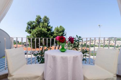 un jarrón de flores sobre una mesa en un balcón en Rooms Jelka, en Dubrovnik