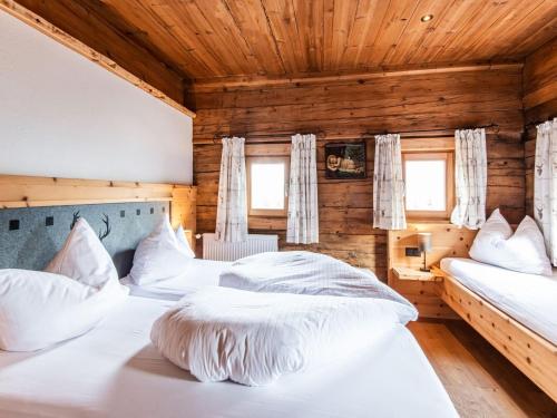 Duas camas num quarto com paredes de madeira em Charming holiday home in Fügenberg with sauna em Fügenberg