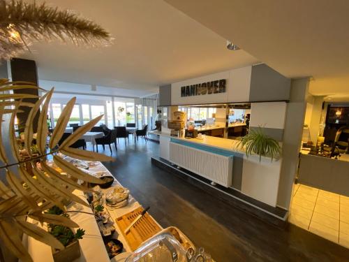 ein Wohnzimmer mit einem Esszimmer und einer Küche in der Unterkunft Pro Messe Hotel Hannover in Hannover