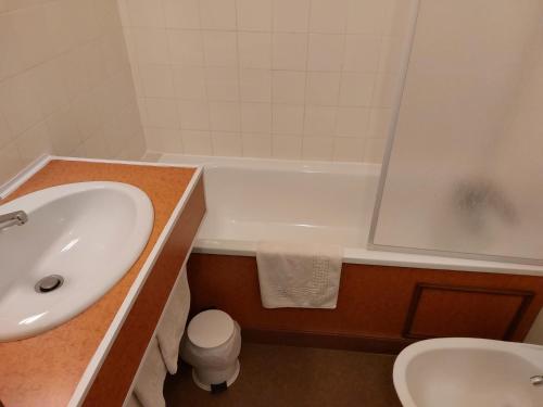 a bathroom with a sink and a tub and a toilet at Le Magiot in Montliot-et-Courcelles