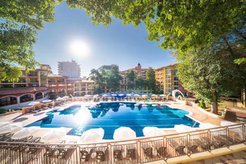 una gran piscina con sillas blancas y un complejo en AquaClub GRIFID Hotel Bolero - Ultra All Inclusive & Private Beach en Golden Sands