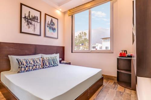 a bedroom with a large white bed and a window at Keys Lite by Lemon Tree Hotels, Tapovan, Rishikesh in Rishīkesh