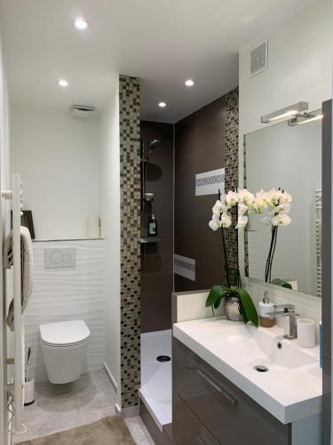 La salle de bains est pourvue de toilettes et d'un lavabo fleuri. dans l'établissement Plage et hippodrome. Parking, à Cagnes-sur-Mer