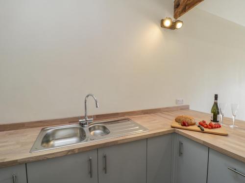 a kitchen with a sink and a cutting board with tomatoes at Shippon in York
