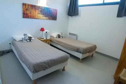 2 lits avec des animaux farcis assis sur eux dans une pièce dans l'établissement Spacieux 4/6 places proche du centre, à Saint-Lary-Soulan