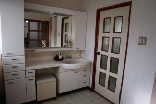 W białej łazience znajduje się umywalka i lustro. w obiekcie Oyado Endo - Vacation STAY 12914v w mieście Sanuki