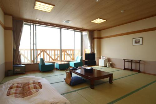 Spa SHIOSAI في Toyoura: غرفة نوم بسرير وطاولة وكراسي