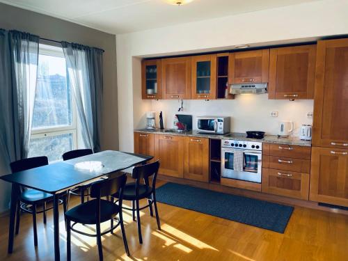 a kitchen with wooden cabinets and a table with chairs at Tallinn Center Apartment in Tallinn