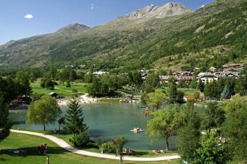 un fiume in una valle con una città e montagne di Résidence Le Chalet de L'Eterlou by Popinns a Saint-Chaffrey