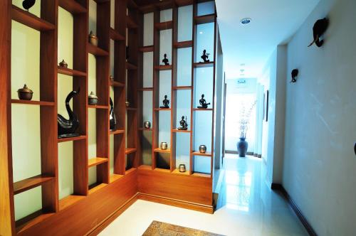 a hallway with wooden shelves with vases on them at Baan Sukhumvit Soi 18 in Bangkok