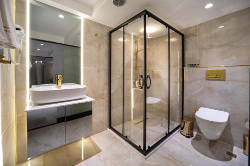 a bathroom with a shower and a toilet and a sink at Walton Gardens Pera in Istanbul