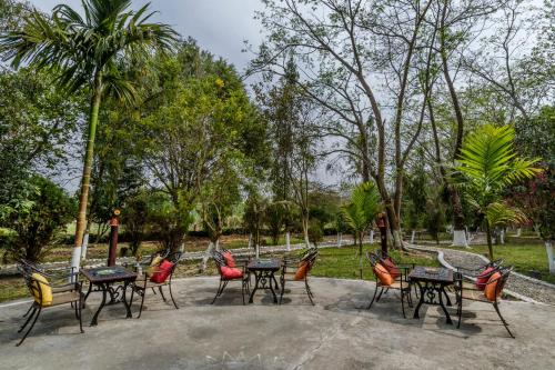 a group of tables and chairs in a park at The Riverwood Forest Retreat Dooars - fully vaccinated staff in Neorā Nadī