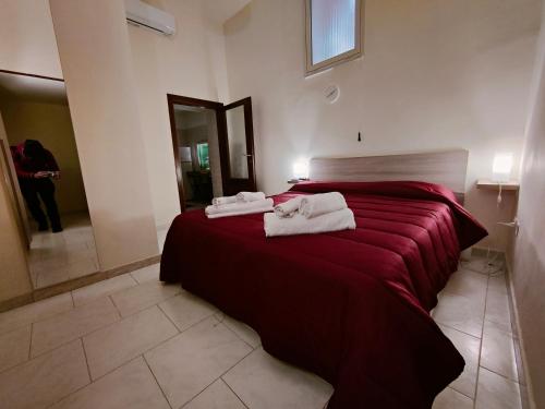 a bedroom with a red bed with towels on it at Casa del Pescatore in Castellammare di Stabia