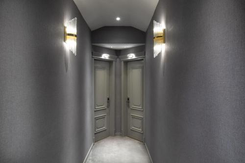 a hallway with two doors and lights on the walls at Walton Gardens Pera in Istanbul