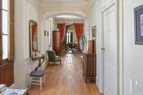 a living room with a hallway with a chair and a table at Château Saint Vincent in Bazas