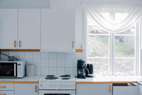 a kitchen with a stove and a microwave and a window at Munkedals Herrgård in Munkedal