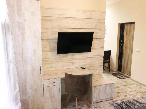 a living room with a wooden wall with a flat screen tv at Апарт-отель "ГАЛАГОВЪ" in Uzhhorod