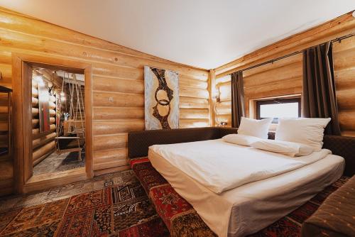 ein Schlafzimmer mit einem Bett in einem Zimmer mit Holzwänden in der Unterkunft Inn OZZ in Qaraghandy