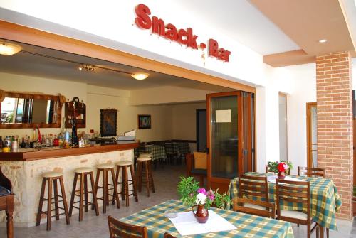 a restaurant with a bar and some tables and chairs at Apollo City Hotel - Maliatim in Malia