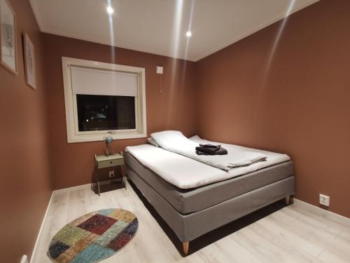 Un dormitorio pequeño con una cama y una ventana. en Hurthi Apartment - Blue House, en Vardø