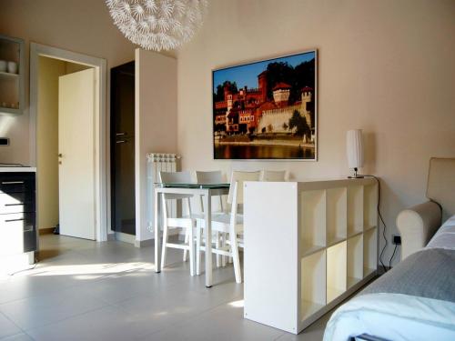 ein Wohnzimmer mit einem Tisch und Stühlen sowie einem Wandgemälde in der Unterkunft Residenza il Nespolo - Estella Hotel Collection in Turin