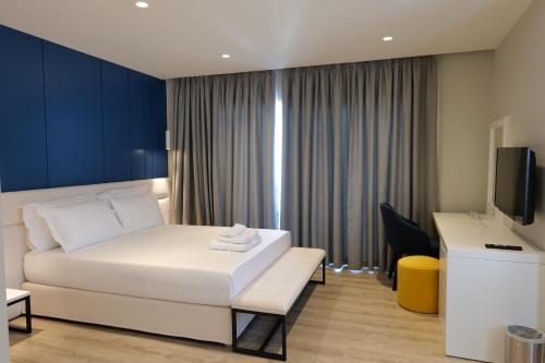 a hotel room with a bed and a tv at Hotel Teuta in Sarandë