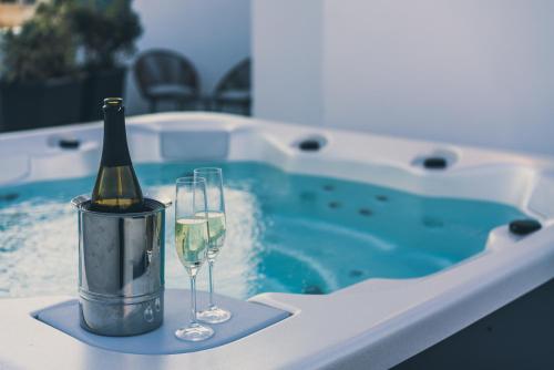 eine Flasche Champagner und zwei Gläser neben dem Pool in der Unterkunft Amery House in Sliema