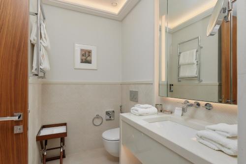 a bathroom with a sink and a toilet and a mirror at Porto Montenegro Residences in Tivat