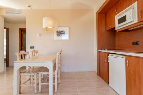 a kitchen and dining room with a table and chairs at Marins Playa in Cala Millor