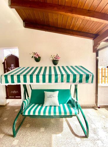 un banco verde y blanco con una mesa en ADV Holiday House - Casa Vacanze, en San Cataldo