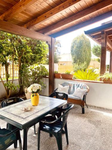 un patio con mesa, sillas y sofá en ADV Holiday House - Casa Vacanze, en San Cataldo