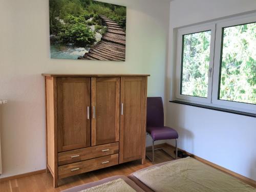 um quarto com um armário de madeira e uma janela em Apartments am Rehgehege Apartment 4 3 OG em Überlingen