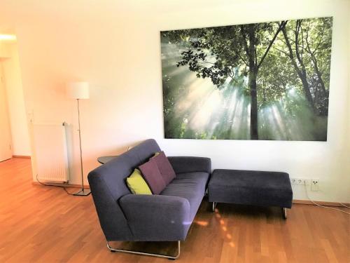 ein Wohnzimmer mit einem Sofa und einem Gemälde an der Wand in der Unterkunft Apartments am Rehgehege Apartment 1 EG in Überlingen
