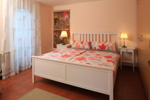 a bedroom with a white bed with flowers on it at Haus Am Sonnenhügel in Bad Urach