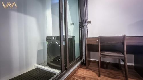 a bathroom with a toilet and a chair next to a desk at VNAHOMES APARTHOTEL in Hanoi