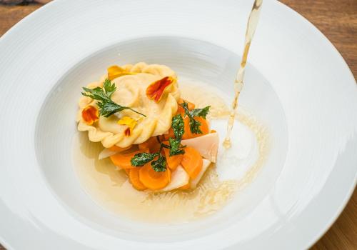 a white plate with a pasta dish with a fork at Matild Country Hotel in Nemesvita