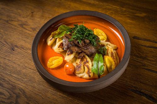 a bowl of soup with meat and vegetables on a table at Matild Country Hotel in Nemesvita