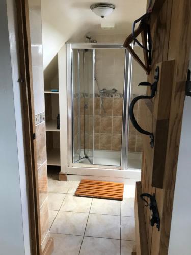 a shower with a glass door in a bathroom at Cosy Cottage in the Countryside in Stafford