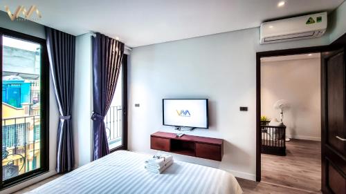 a bedroom with a bed and a tv on a wall at VNAHOMES APARTHOTEL in Hanoi