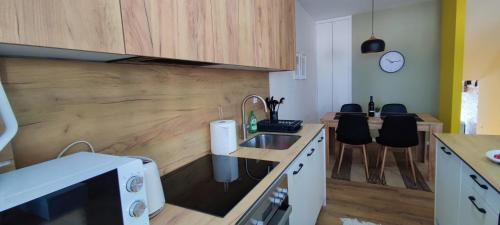 a kitchen with a sink and a counter with chairs at Apartment 906 in Prishtina in Pristina