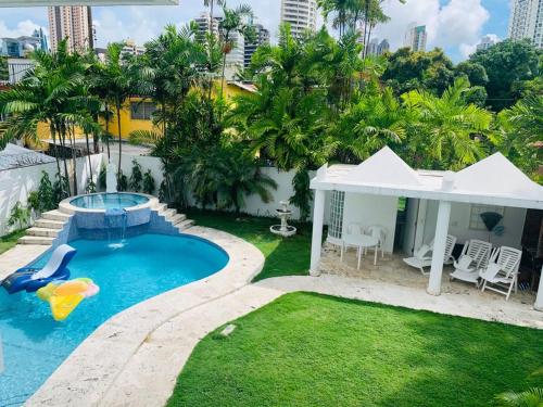 a backyard with a pool and a slide in the grass at Casa Duplex Privada con Piscina with Ride from Airport in Panama City