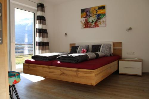 a bedroom with a wooden bed with a red couch at Apart Maria in Jerzens