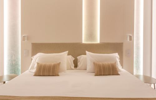 a large white bed with two pillows on it at Marins Playa in Cala Millor