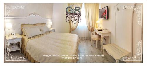 een witte slaapkamer met een bed en een bureau bij Alloggio Turistico GIULIETTA e Romeo Intero Appartamento Centro Villafranca di Verona, Zimmer, Holiday Rooms in Villafranca di Verona